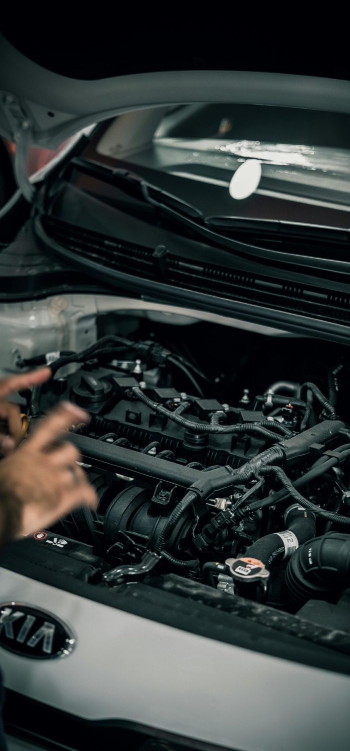Close-up view of a car engine compartment with an open hood focusing on the complex layout of the engine blocks and components